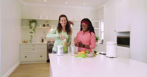 Diverse Friends Making Healthy Smoothies in Modern Kitchen
