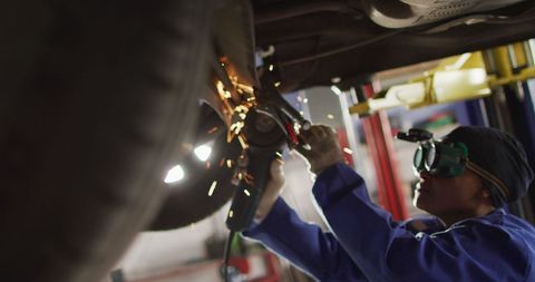 Female Car Mechanic Using Grinder Beneath Vehicle in Garage - Download Free Stock Images Pikwizard.com