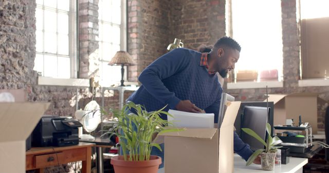 Man packing his belongings in office environment - Download Free Stock Images Pikwizard.com