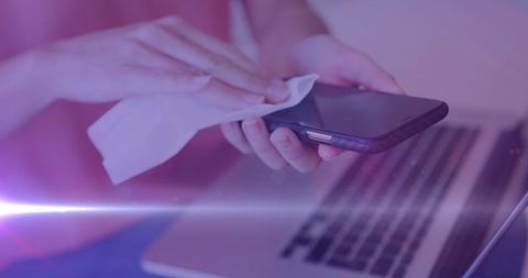 Person Disinfecting Smartphone with Purple Hue - Download Free Stock Images Pikwizard.com