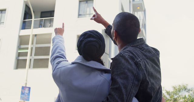 Couple Pointing at Apartment Building Together - Download Free Stock Images Pikwizard.com