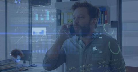 Businessman Analyzing Data While Engaging in Phone Conversation