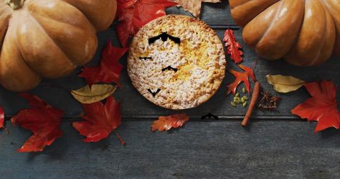 Autumn leaves with pumpkin pie on rustic wood table