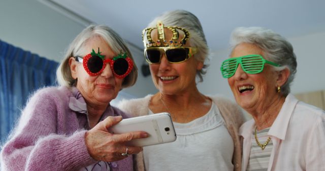 Three senior women share a cheerful selfie moment with whimsical accessories. - Download Free Stock Photos Pikwizard.com