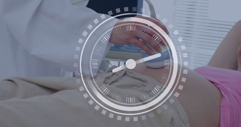 Pregnant woman having ultrasound examination with digital clock overlay