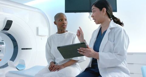 Clinician consulting patient before ct scan using tablet in radiology department