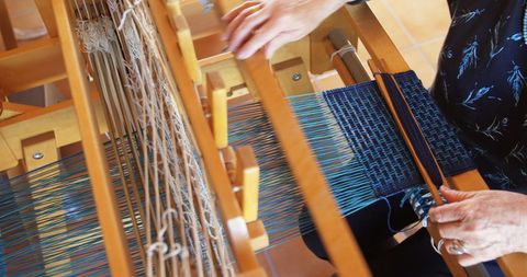 Senior Woman Weaving Cloth on Traditional Handloom