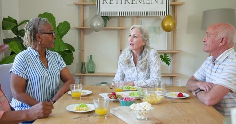 Senior Friends Enjoying a Retirement Celebration Gathering with Snacks