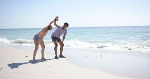 Couple Bonding Through Beach Workout Stretches by Ocean - Download Free Stock Images Pikwizard.com