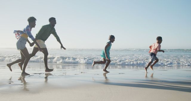 A group of children is running and playing along a sandy beach with ocean waves in the background. This joyful scene is ideal for use in marketing materials, travel and tourism advertisements, family vacation promotions, and websites focusing on leisure activities and child wellness.