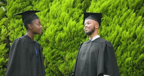 Happy african american graduates celebrating achievement outdoors