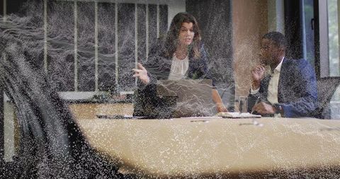 Professionals Engaging in Lively Discussion in Modern Boardroom