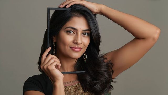 Elegant woman holding frame in studio setting