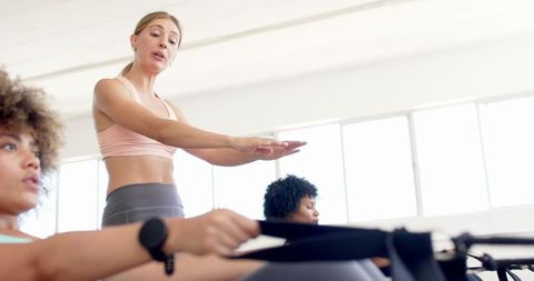 Female Fitness Instructor Leading Pilates Class in Bright Studio