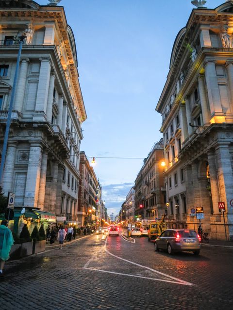Historic street in Rome with evening lights and busy traffic - Download Free Stock Photos Pikwizard.com
