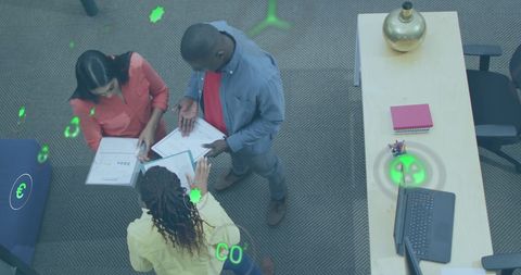 Diverse Team Discussing Reports with Digital Overlay and Green Icons