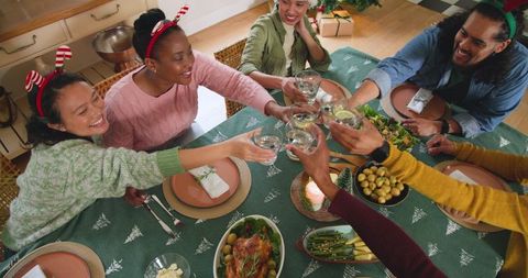 Diverse Group Toasting Holiday Feast with Laughter and Joy