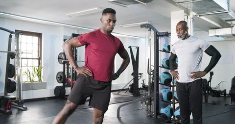 Personal trainer guiding client in dynamic stretching routine