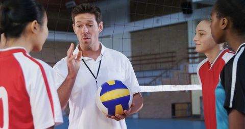 Volleyball Coach Guiding Young Players on Indoor Gym Court