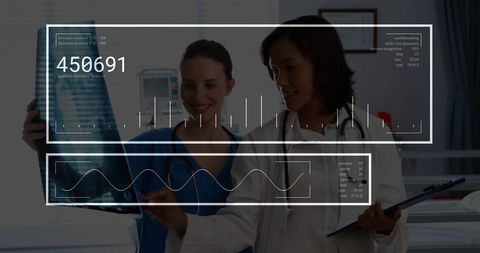 Two medical professionals analyzing x-ray showing medical data visualization