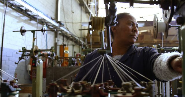 A skilled African American worker operates industrial machinery with focus and expertise. - Download Free Stock Photos Pikwizard.com