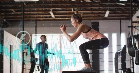 Woman performing box jump plyometrics in industrial gym with fitness data overlays