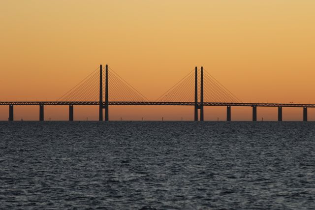 Ocean and bridge captured at sunset. Ideal for travel blogs, architectural and engineering articles, Scandinavian tourism promotion, and infrastructure planning presentations.
