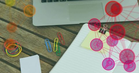 Open notebook with sticky note, laptop and stationery on rustic desk with network overlay