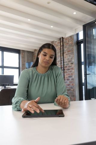 Professional Woman Using Tablet in Modern Loft Office