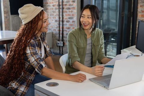 Diverse female coworkers collaborating at modern office workspace