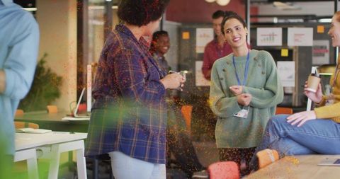 Leading woman in green knit sweater guiding team discussion in modern open-plan office