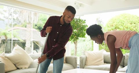 Couple collaborating on living room cleaning task together