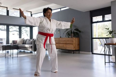 Senior Asian Woman Practicing Martial Arts at Home