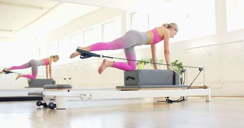 Woman Practicing Pilates on Reformer Machine in Bright Studio - Download Free Stock Images Pikwizard.com