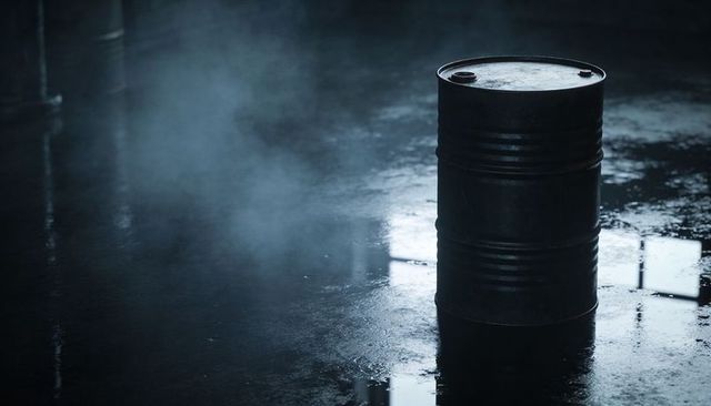 Moody Industrial Drum Standing on Wet Concrete Floor Reflecting Window Light