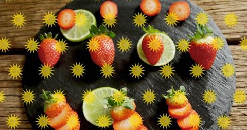 Fresh strawberries and halved limes arranged on slate with yellow starburst overlay