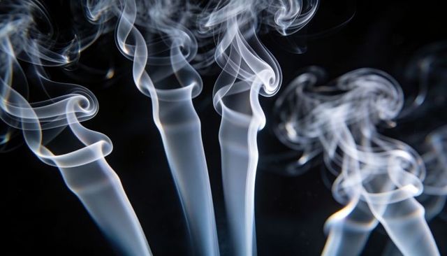 Ethereal white smoke plumes curling and rising on black backdrop for abstract design