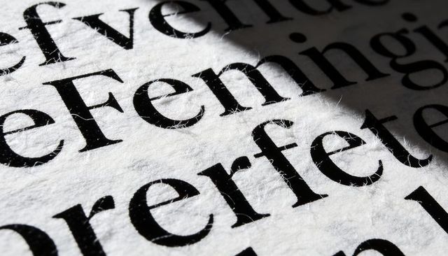 Macro showing black serif typography on thick fibrous paper with visible ink texture