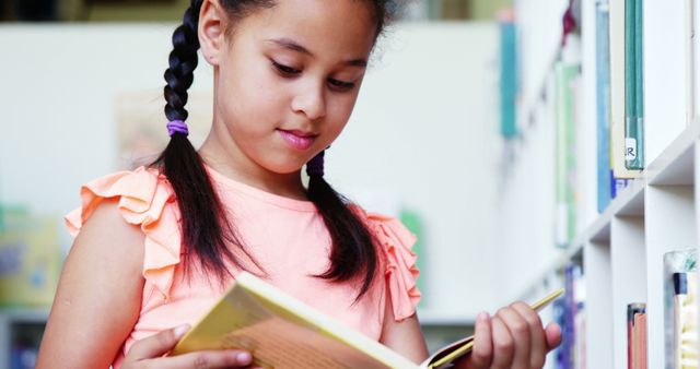 Schoolgirl Engrossed in Reading at Library Book Shelf - Download Free Stock Images Pikwizard.com