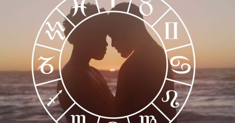 Silhouette Couple Embracing with Zodiac Symbols at Sunset Beach