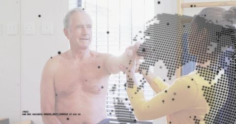 Senior man receiving shoulder rehabilitation while female therapist supporting raised arm