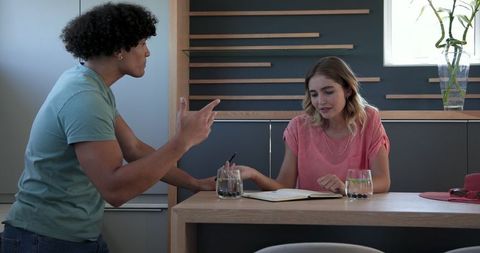 Young Couple Collaborating on Plans at Kitchen Counter