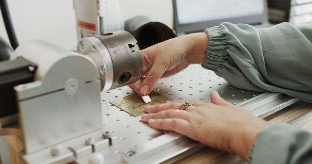 Female technician operating CNC machine, highlighting precision machining in a workshop environment. Ideal for use in articles or materials focused on modern manufacturing, engineering education, or technology advancement. Highlights technical skill and modern machinery.