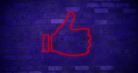 Neon Red Thumbs Up Icon on Brick Wall Background