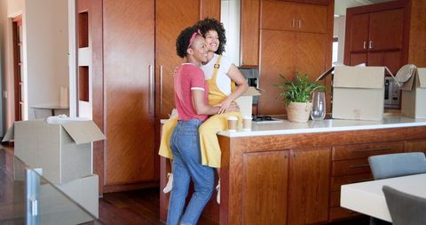 Joyful reunion of women celebrating new home kitchen