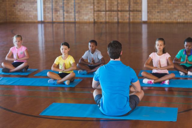 School Kids Meditating with Teacher in Gym - Download Free Stock Photos Pikwizard.com