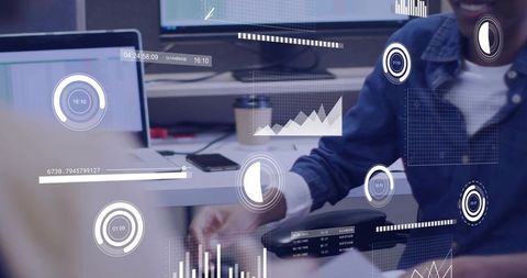 Data analyst typing with hud analytics overlays at modern office workstation with dashboards