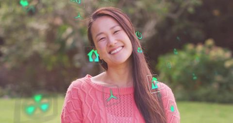 Smiling woman embracing eco-friendly technology outdoors