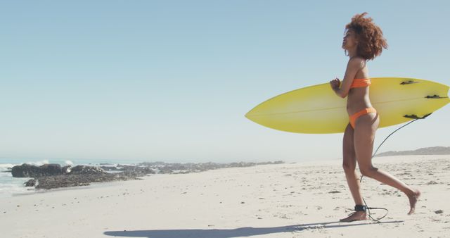Happy biracial woman walking on beach, smiling and holding surfboard - Download Free Stock Photos Pikwizard.com