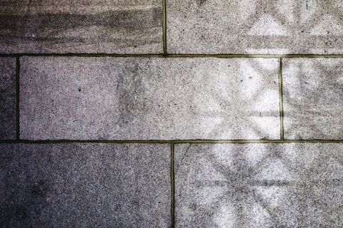 Shadowed stone wall with geometric patterns
